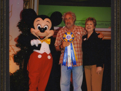 Happy couple posing with Mickey Mouse